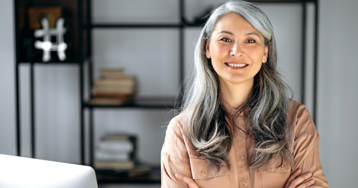 A woman with gray hair smiling after her cataract surgery.