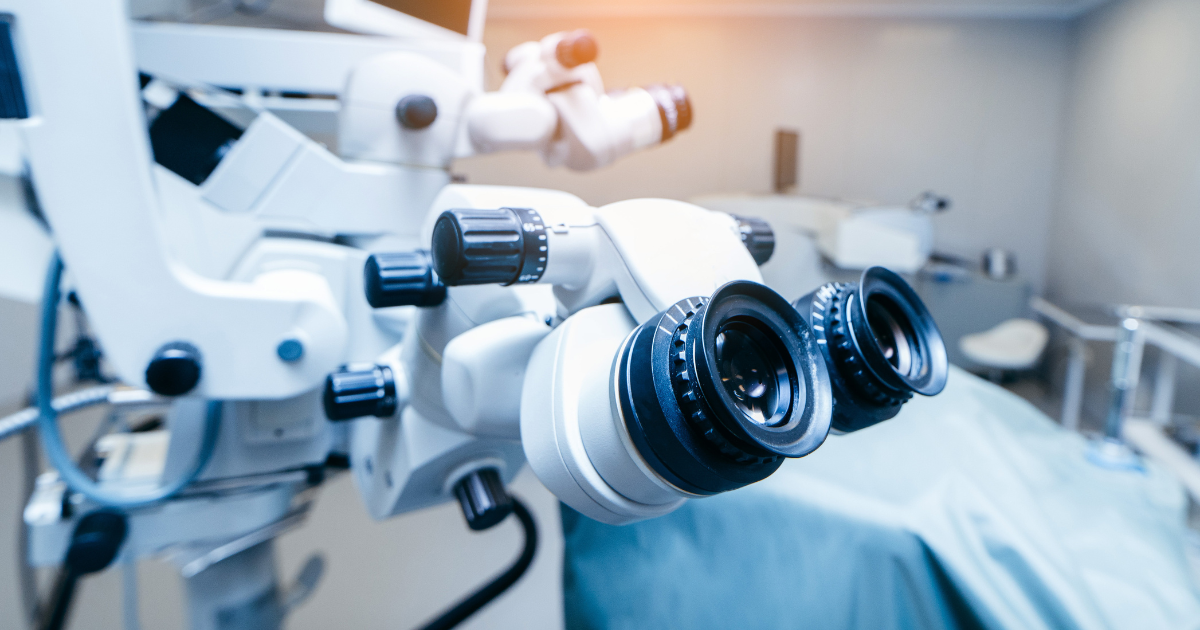 In an eye surgery room showing a patient bed and surgerical instruments for cataract removal.