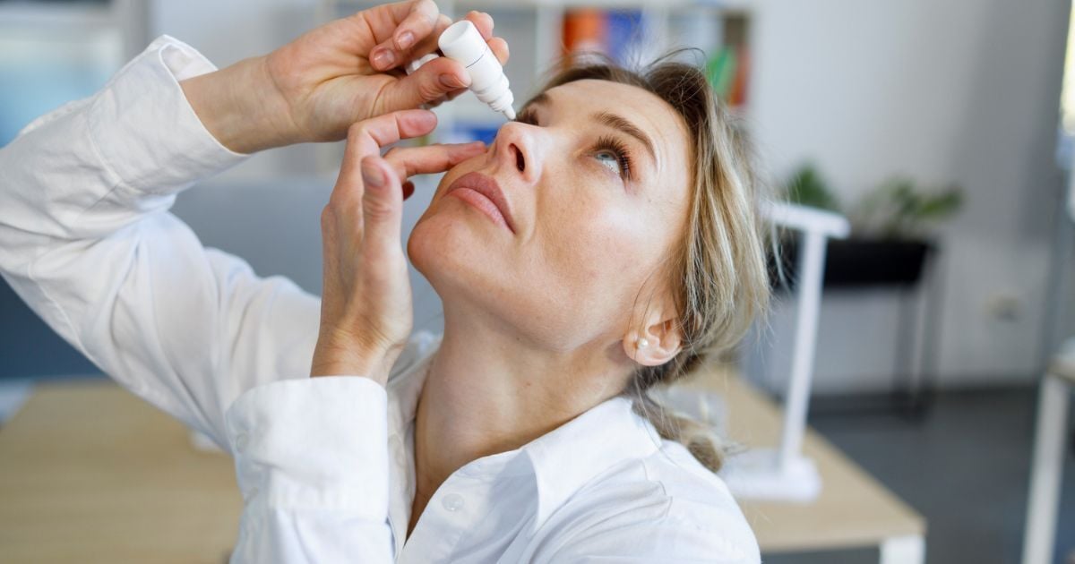 A woman putting eye drops in her eyes to manage her glaucoma.