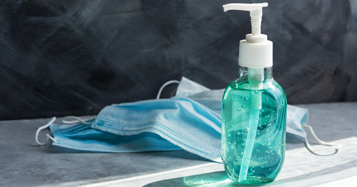 Hand sanitizer and masks on a table.