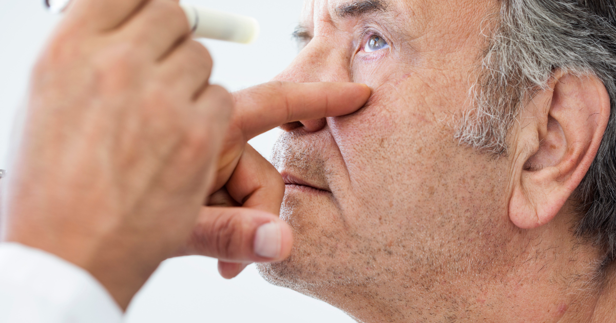 An older man having his eyes examined for cataracts.