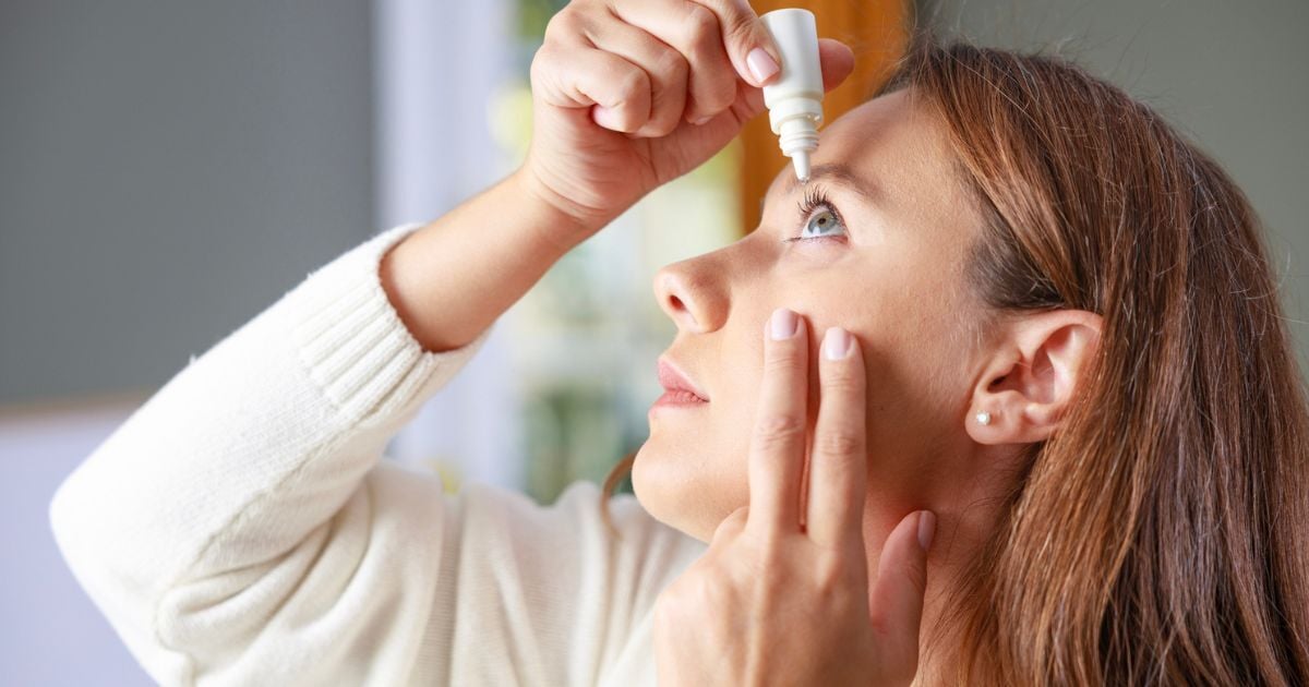 A woman putting in tear drops for her moderate dry eye.