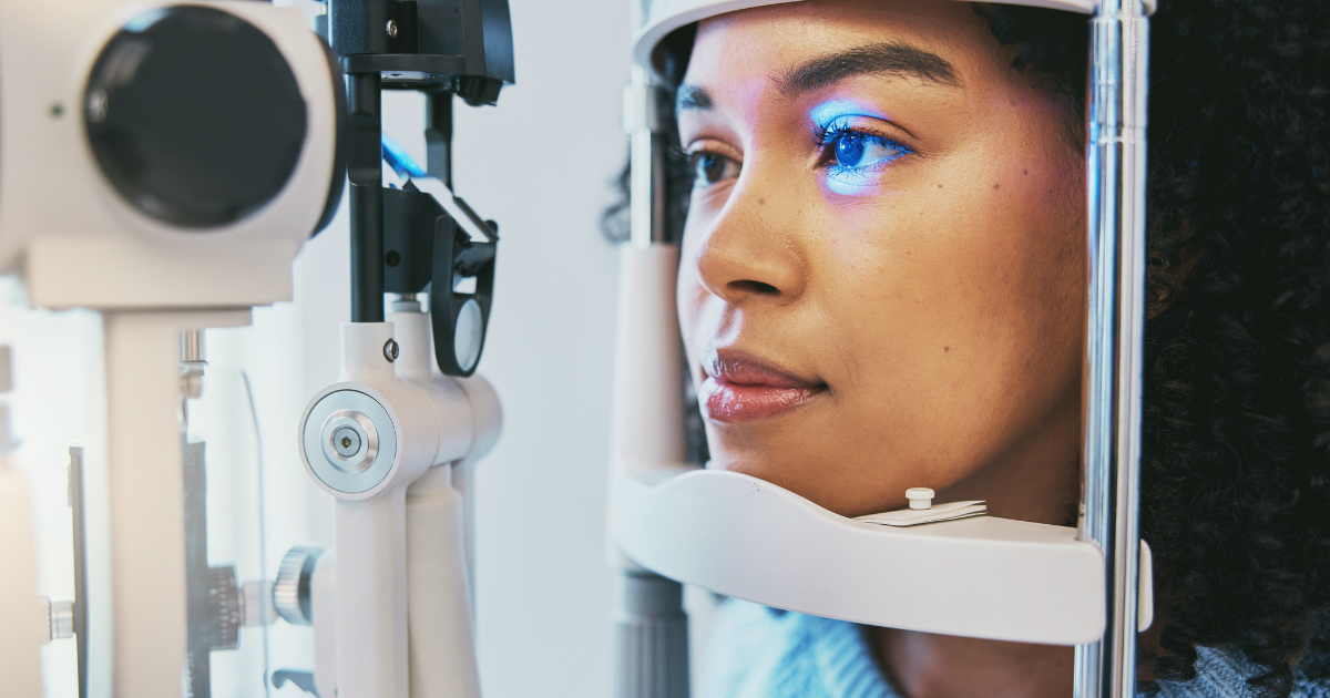 A young woman getting her eyes examined with an optics machine.