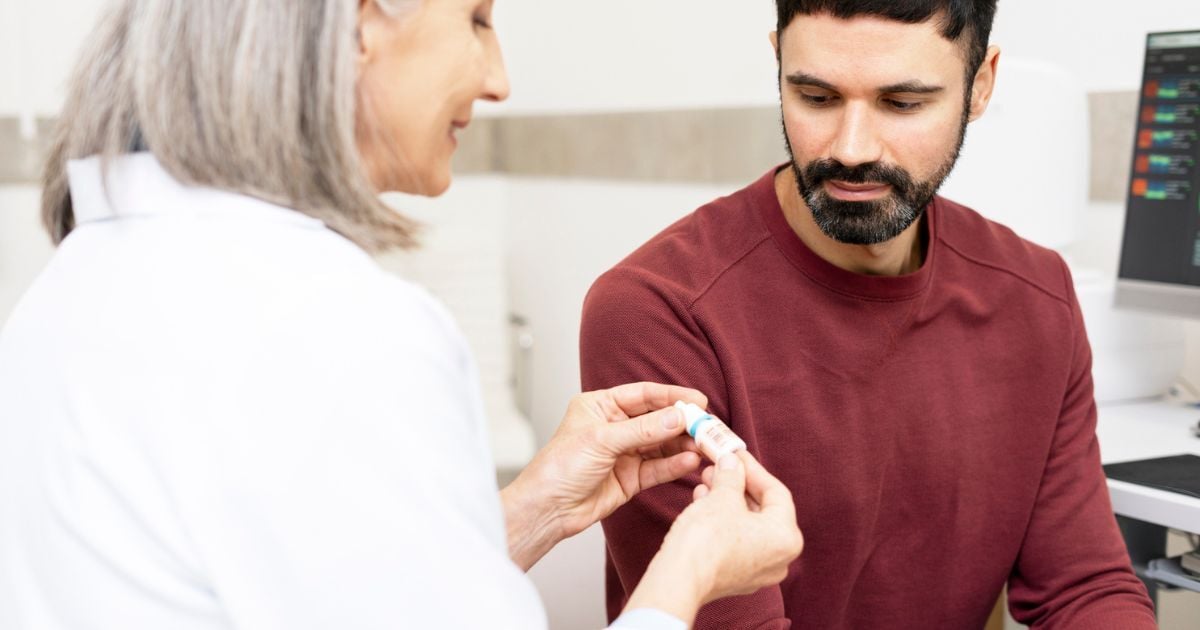 Eye doctor talking to patient about prescription eye drops for dry eye.