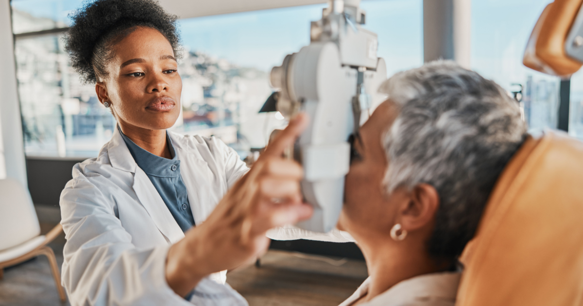 An eye doctor giving an older woman an eye exam.