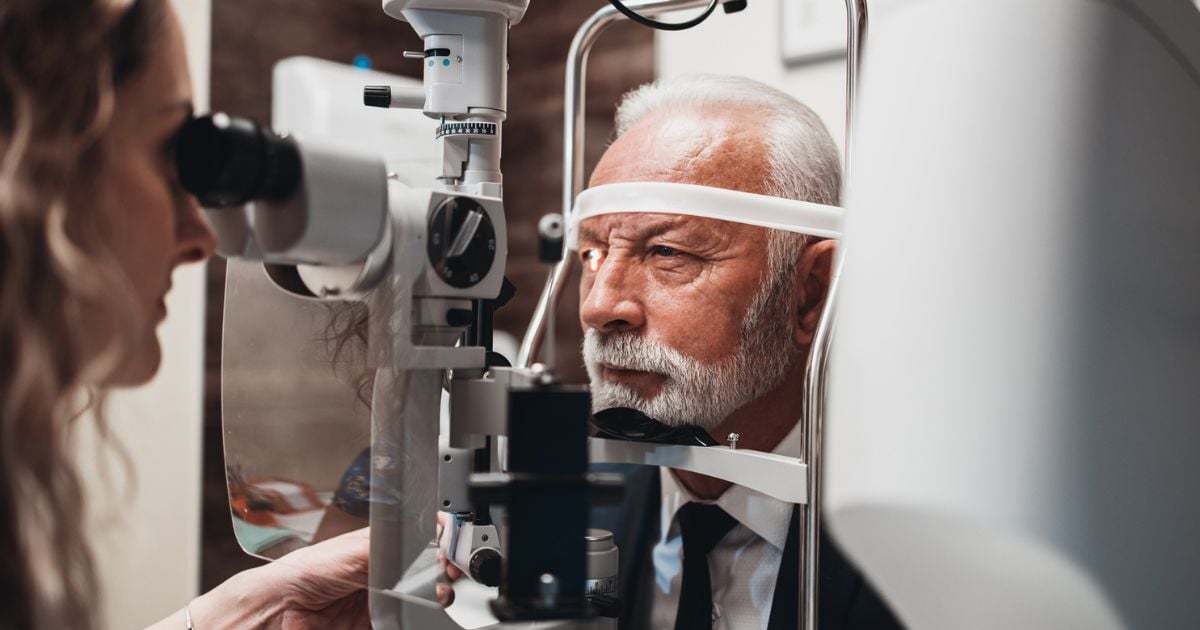 An older man at the eye doctor's office having his eyes checked.