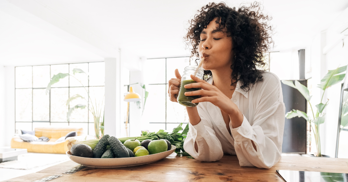 A woman drinking a smoothie to help keep her eyes healthly.
