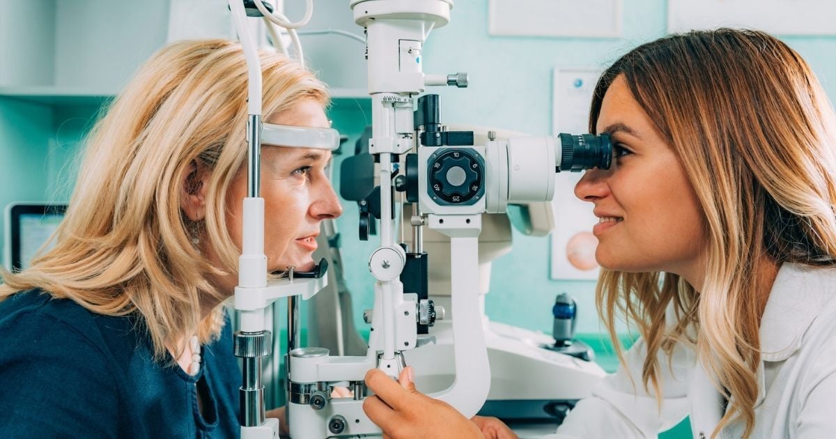 An older woman at an eye appointment having her eyes checked.