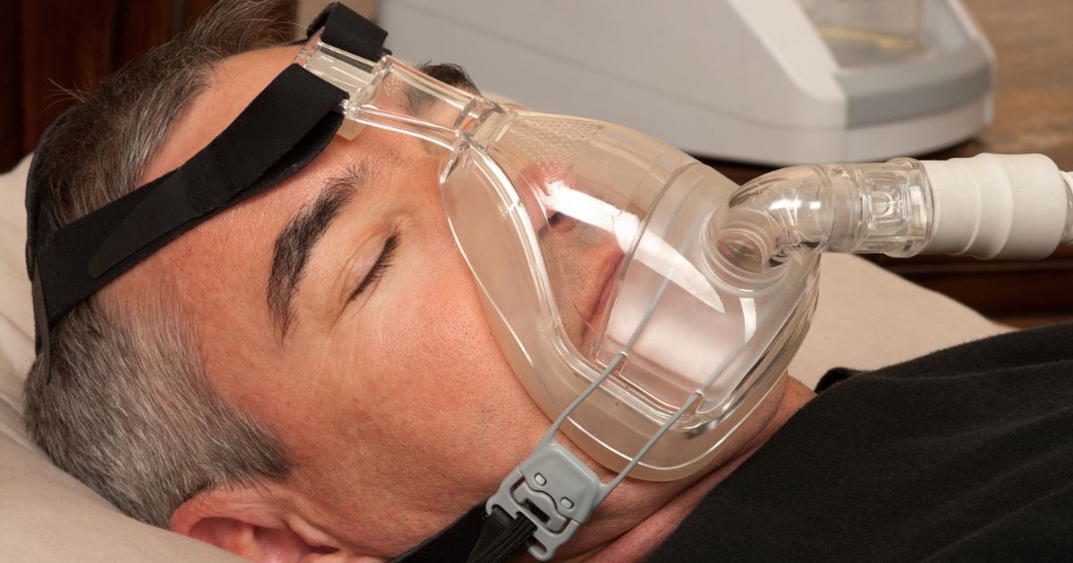 A man using a CPAP machine for his sleep apena.